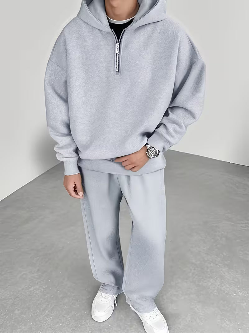 Ensemble deux pièces pour homme comprenant un sweat à capuche zippé à demi-zip avec doublure polaire et un pantalon polaire assorti.
